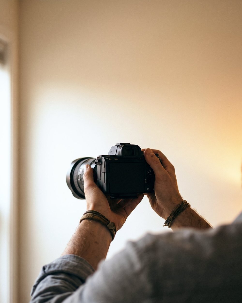 A gdj photographer framing a shot on a mirrorless camera during an on-location shoot
