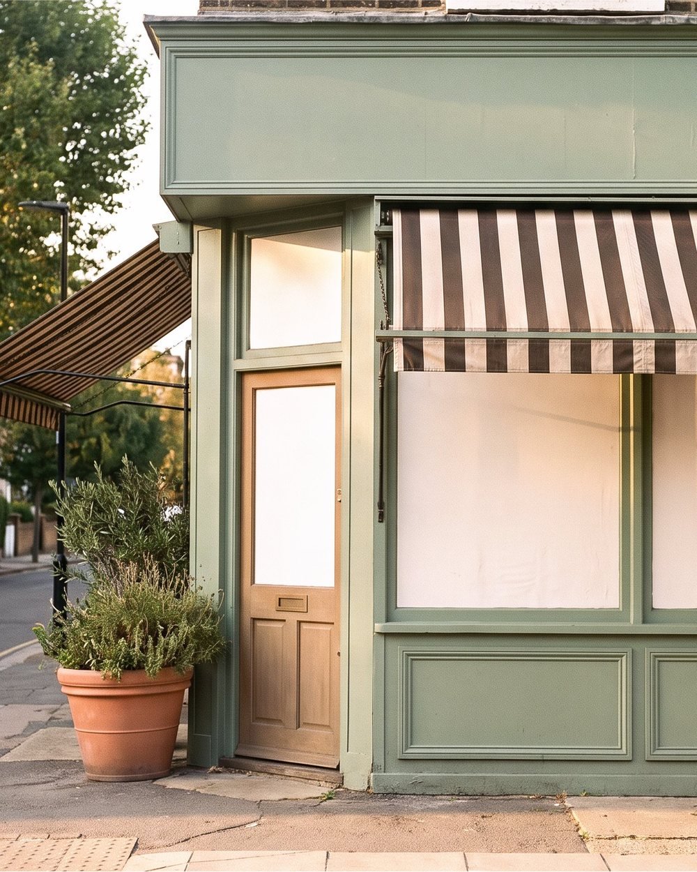 A small independent storefront with sage-painted trim on a quiet neighbourhood street